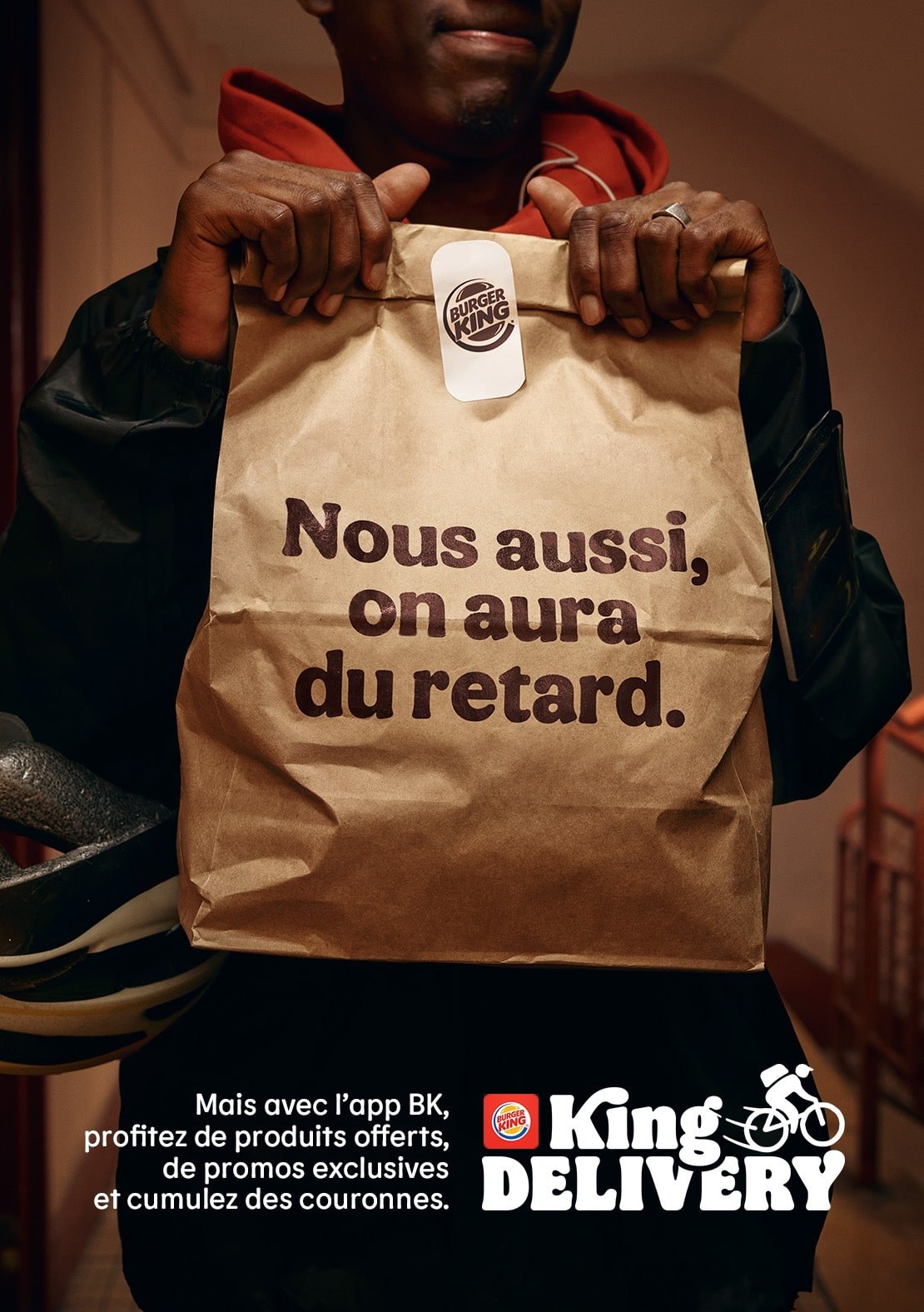Affiche « Nous aussi, on aura du retard. » : un livreur tient un sac Burger King