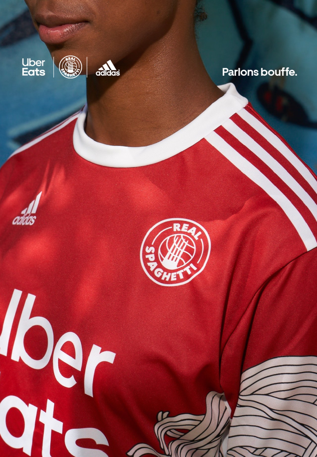 Gros plan sur un maillot rouge Uber Eats × Adidas « Real Spaghetti »